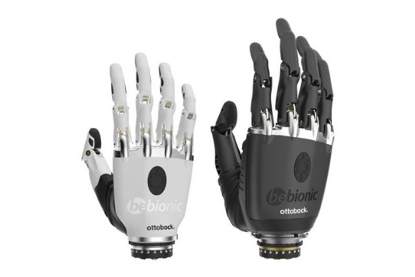 Two myoelectric hands, one white and one black. Both with life-like joints on thumbs and fingers. 