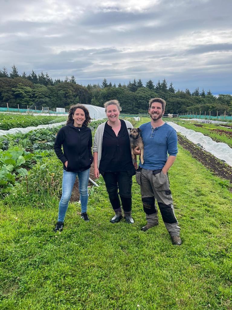 Image shows three members of the Woodside Arran team with polytunnels and produce in the background.