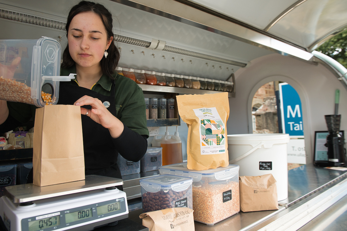 Evie weighing food in the Ullapool Unpacked C.I.C. Van