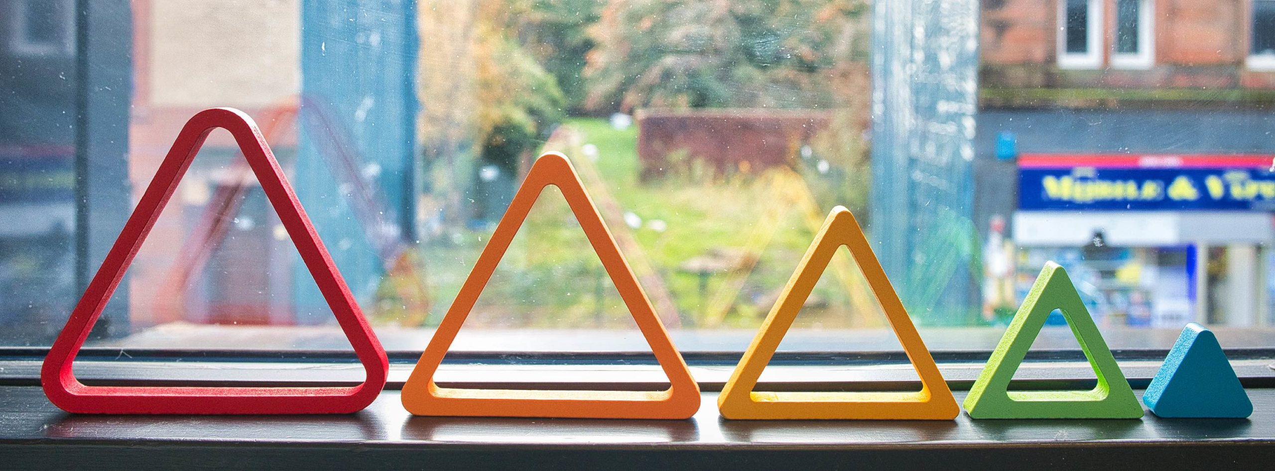 Image of rainbow triangles in the window of Kaleidoscope Counselling