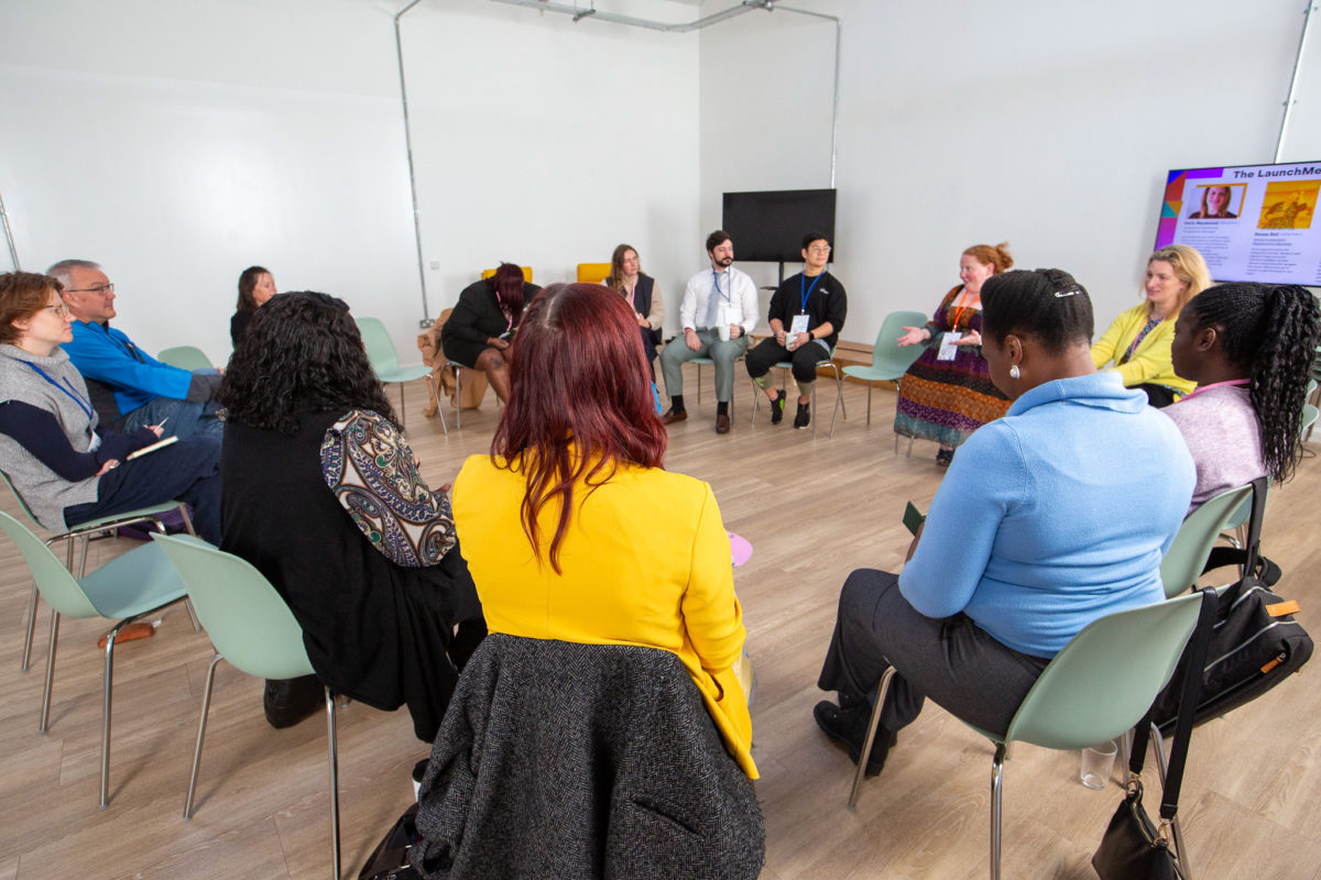 Image of people sitting in a circle at the LaunchMe event listening to Renae from Firstport present