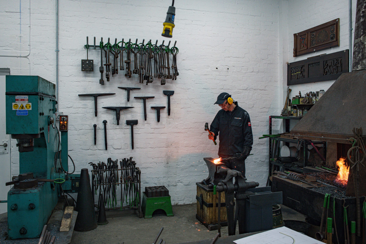 Image of Jack with tools hanging on a wall behind him