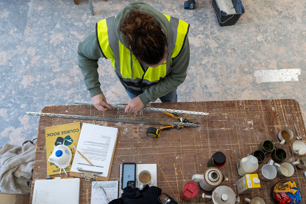 A person measuring and using tools with Glasgow Trades Collective.