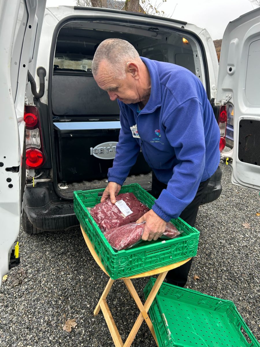 A staff member of Fair Feast packing venison meat into a van