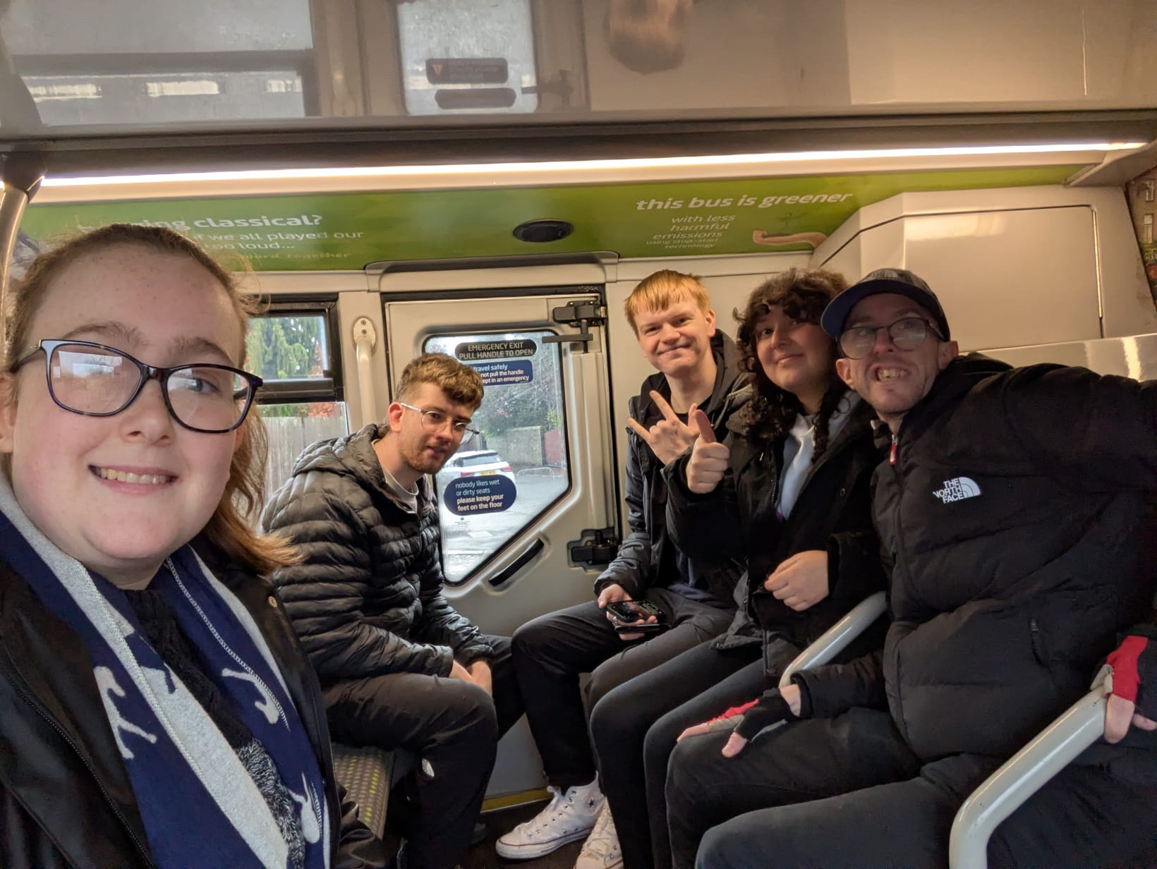 Image of people on a bus looking at the camera