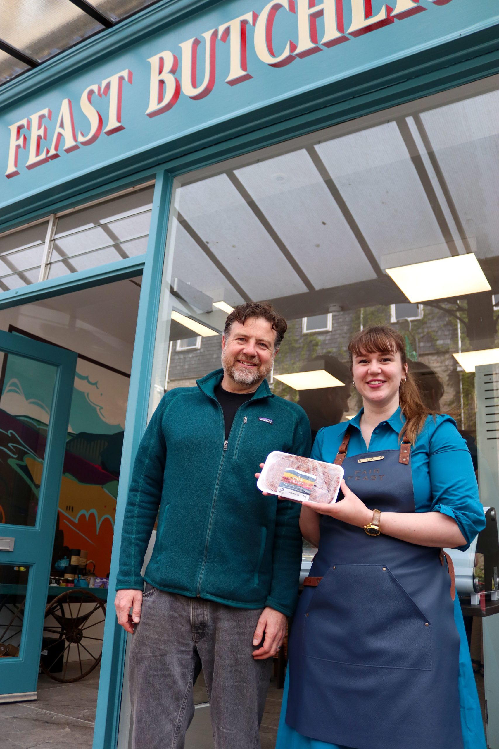 Helen Stewart and a colleague stand smiling outside the Fair Feast butcher shop