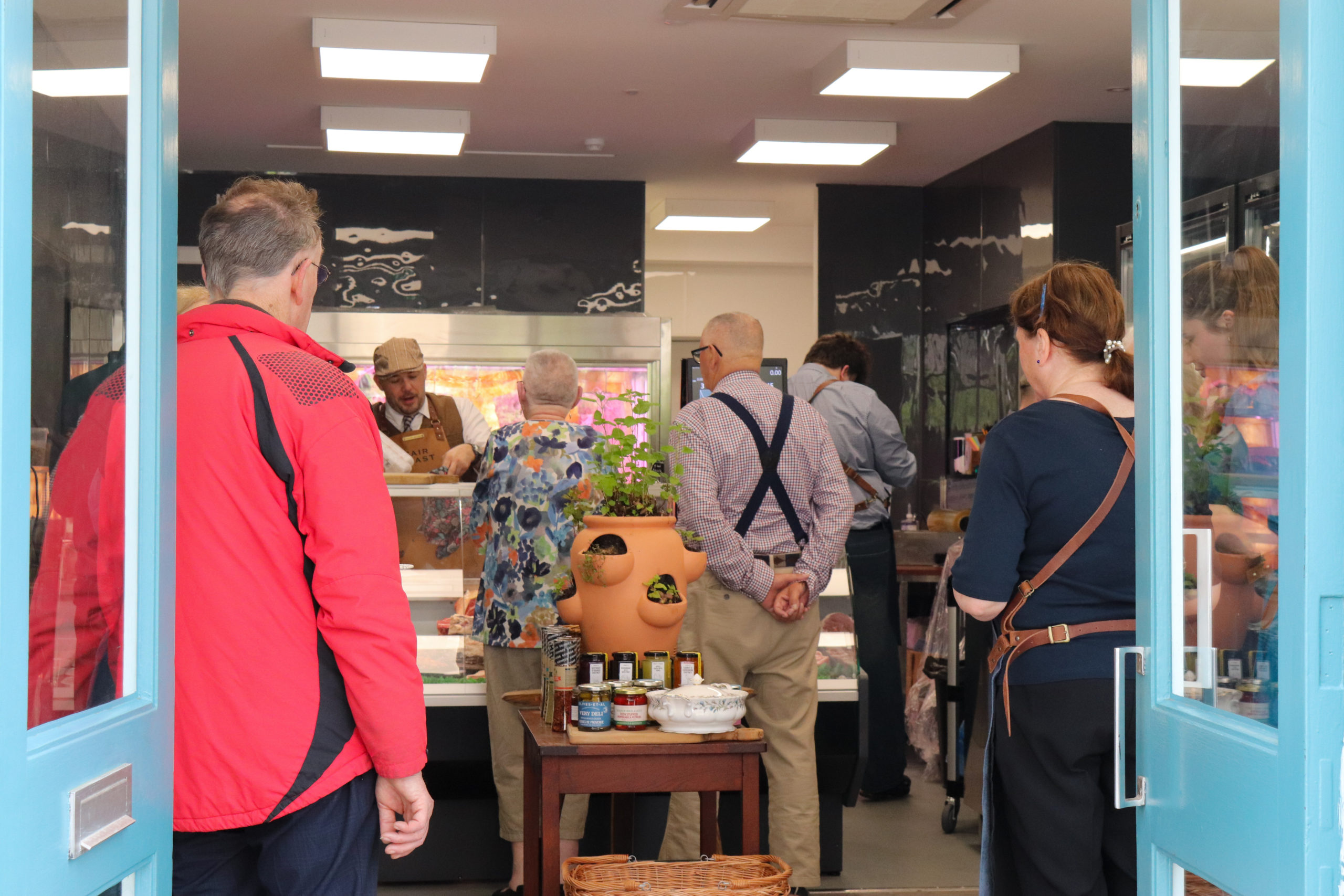 Lots of customers stand inside the Fair Feast butcher's shop